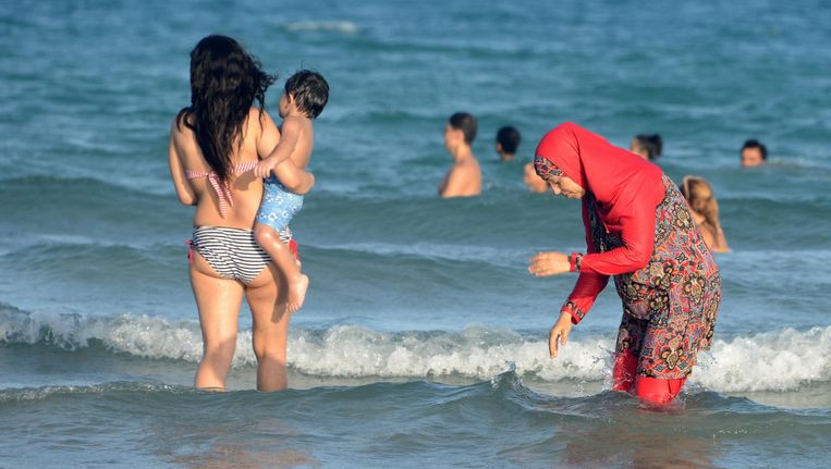 Een vrouwelijke badgast draagt een boerkini op het strand van de Tunesische plaats Ghar al Mehl. Beeld afp
