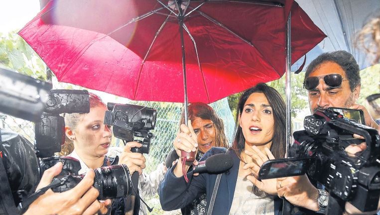 De nieuwe burgemeester van Rome, Virginia Raggi, wordt bij het verlaten van haar huis belaagd door journalisten. Beeld ap