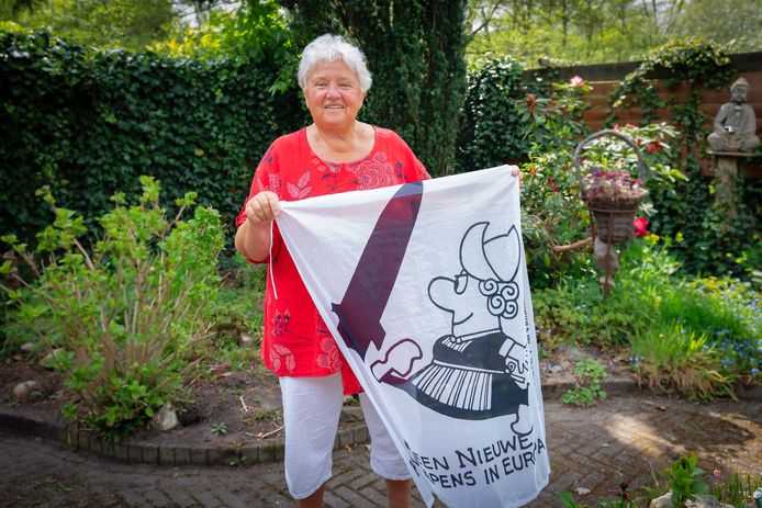 Mariëtte Moors (79) in haar tuin in Geldrop, met een originele demonstratievlag uit 1984 tegen kernwapens.