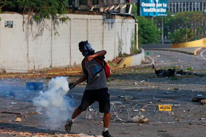 Een aanhanger van Guiado gooit traangas in Caracas.