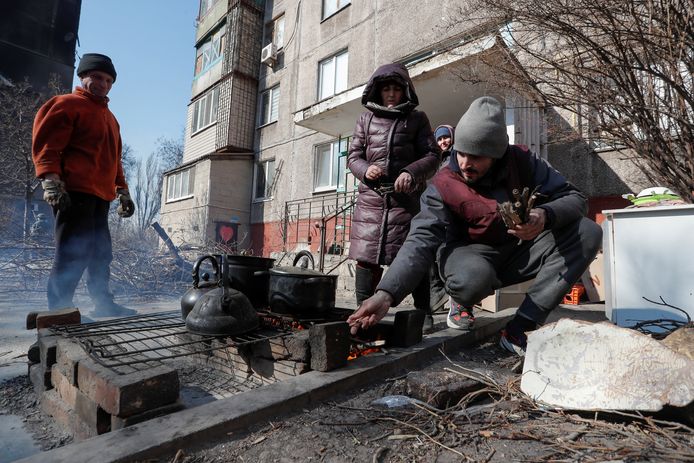 Oekraïeners koken buiten omdat hun huizen zijn vernield, Marioepol.