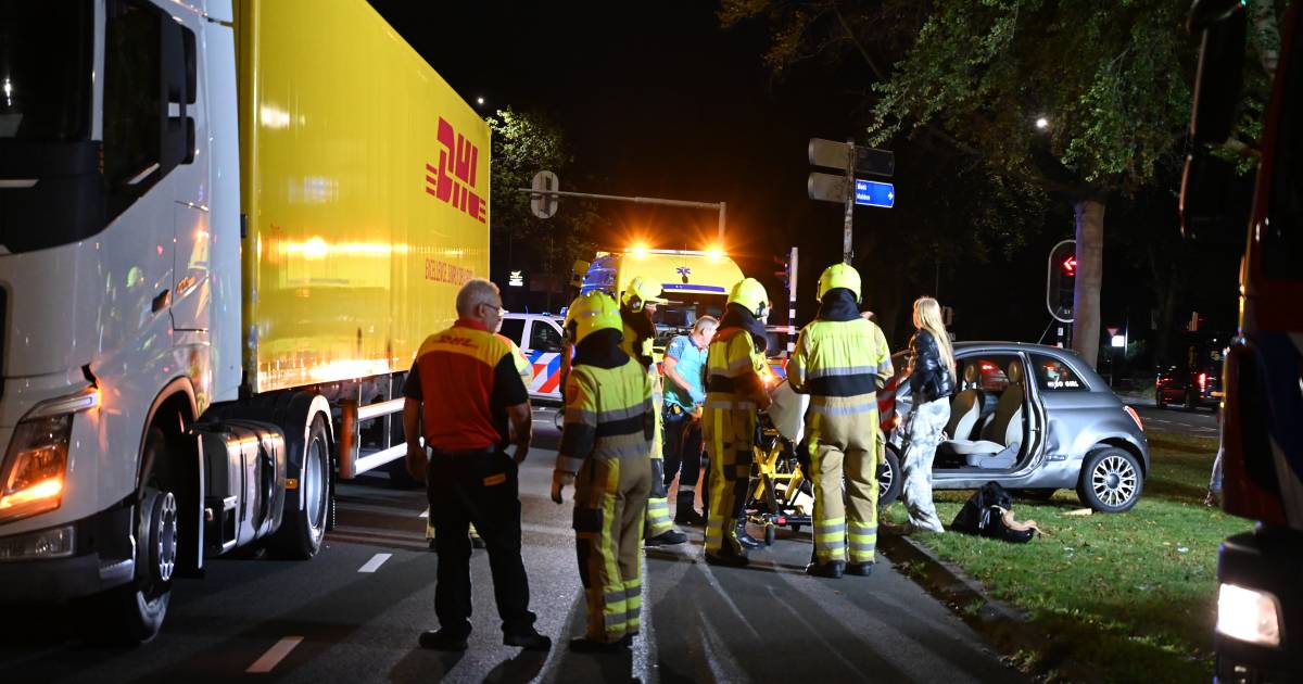 Brandweer bevrijdt gewonde automobilist uit voertuig na botsing met vrachtwagen.
