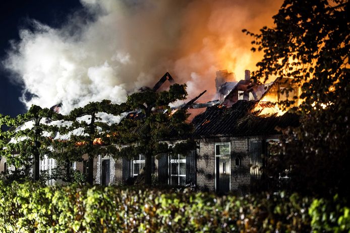 Een woning getroffen door brand. De brand in de woning met een rieten kap is mogelijk door bliksem ontstaan.