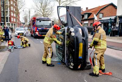 Auto belandt op zijkant bij botsing in Oosterhout, brandweer haalt vrouw eruit