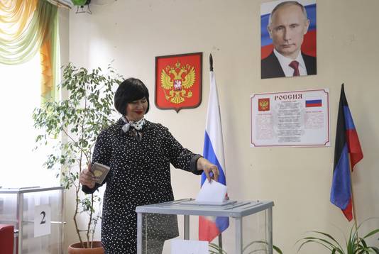 Een vrouw brengt haar stem uit in een stembureau te Donetsk, in een van de door Rusland bezette gebieden.