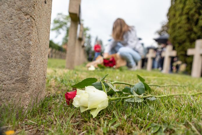 De aanwezige jeugd plaatste een witte en een rode roos bij de graven aan de Bredaseweg tijdens de herdenking