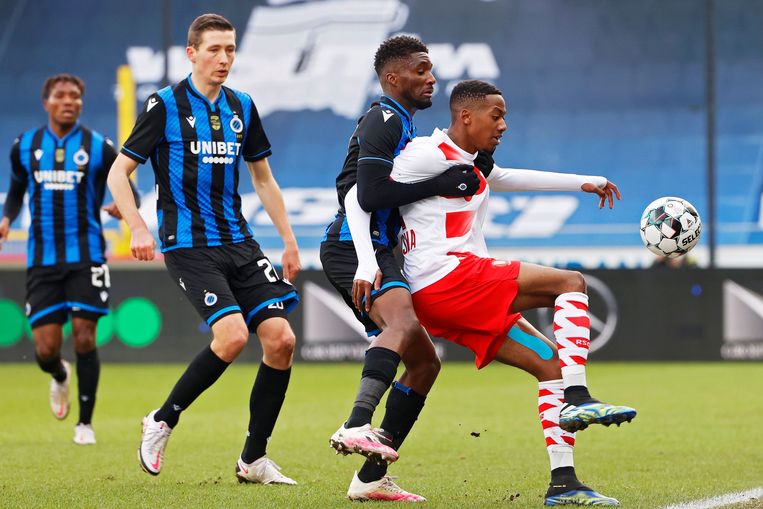 Michel Ange Balikwisha van Standard zit in de greep van Clinton Mata. Hans Vanaken geft rugdekking. Beeld Photo News