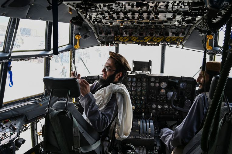 Talibanstrijders in een cockpit van een Afghaans vliegtuig op 31 augustus, de dag dat ook de laatste Amerikaanse troepen zich terugtrokken uit het land.  Beeld AFP