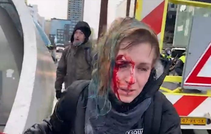Met een bebloed gezicht loopt Denisa Štastná richting station nadat ze door een waterstraal is geraakt.