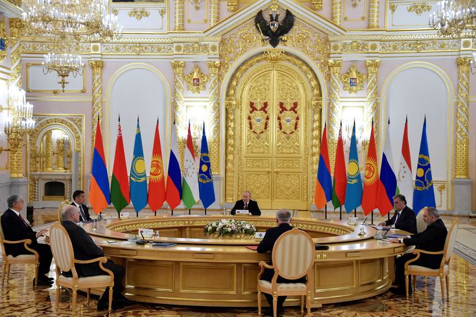 Een door Poetin voorgezeten vergadering met van links naar rechts de vlaggen van Armenië, Wit-Rusland, Kazachstan, Kirgizië, Rusland, Turkmenistan en de CSTO