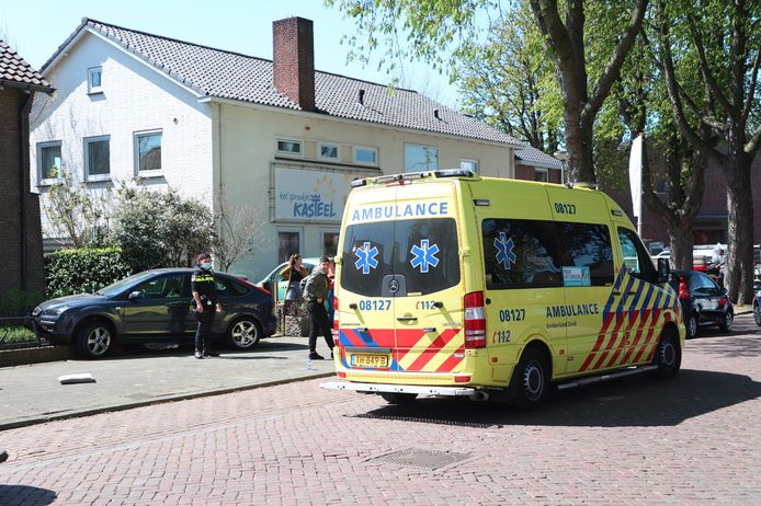 De auto staat nog op het muurtje. De bestuurder wordt behandeld door ambulancebroeders.