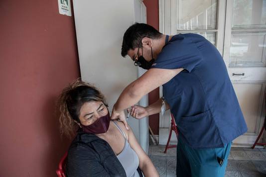 Een Chileense vrouw wordt ingeënt met het Chinese CoronaVac-vaccin. 