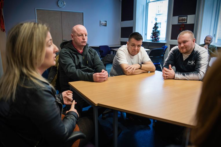Ex-verslaafden Peter Costello, Jeff Black en Barry McDonald (v.l.n.r.) en Austin Smith (rechts achterin) van het Scottish Drugs Forum luisteren naar het verhaal van Laura MacAulay (links).  Beeld Bram Lammers