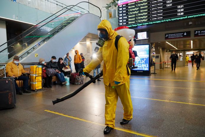 Een stadsmedewerker desinfecteert een station in Moskou.