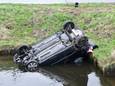 De auto belandde in een watergang nadat twee auto's botsten.