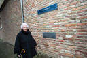 Maria Sieders-Eggink bij de Apenstert, waar een straatnaambord en een plaquette herinneren aan de zwarte zaterdag 14 oktober 1944.