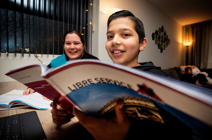 Kim Hofstede en haar zoon Jamal (12). Jamal zit aan de keukentafel en moeder helpt met overhoren.