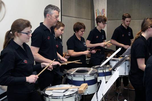 De drumband test de akoestiek van het nieuwe gebouw uit.