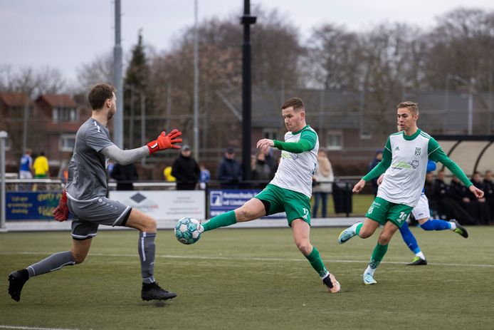 Doelman Sam van Rooij van Marvilde wordt op de proef gesteld door Sammy Dirkx van Geldrop. Rechts Hugo Deenen.