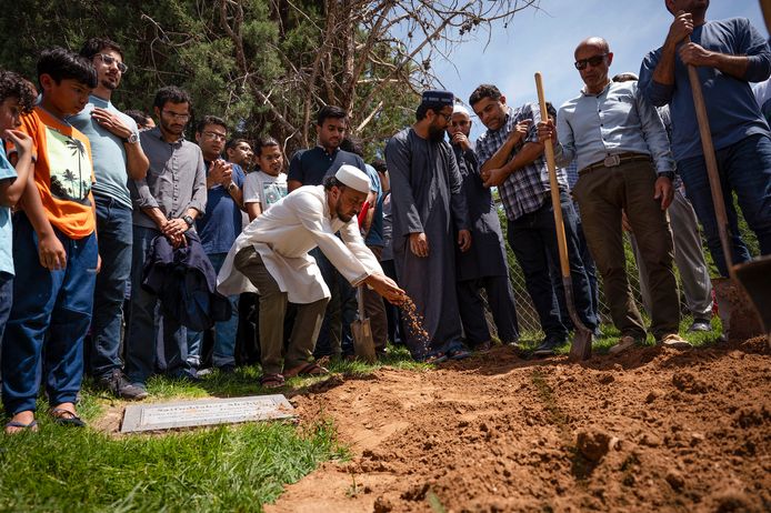 Nabestaanden gooien aarde op het graf van de 27-jarige Muhammad Afzaal Hussain, die begin deze maand in Albuquerque vermoord werd.