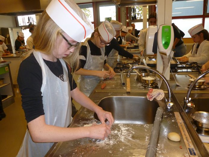 De 11-jarige Melissa is druk bezig met het rollen van haar worstenbroodjes.
