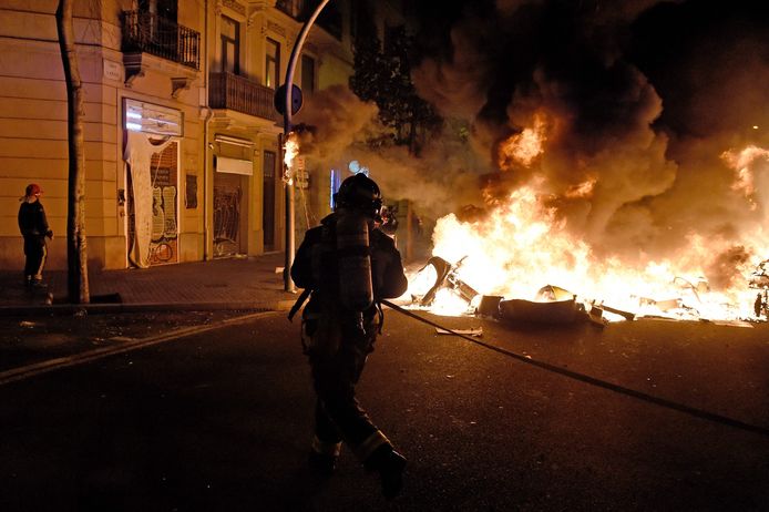 De brandweer van Barcelona blust vuur dat door de relschoppers werd aangestoken.