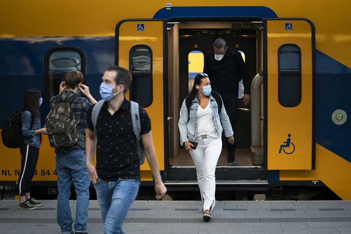 Reizigers met mondkapjes op het perron van Utrecht Centraal. De treinen rijden weer volgens de reguliere dienstregeling, nu het coronavirus over de piek heen is.