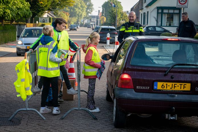 Leerlingen van basisschool Samsam in Oosterhout leggen, met hulp van wijkagent Ronald Klarenbeek, nog eens het belang van dertig kilometer per uur uit.