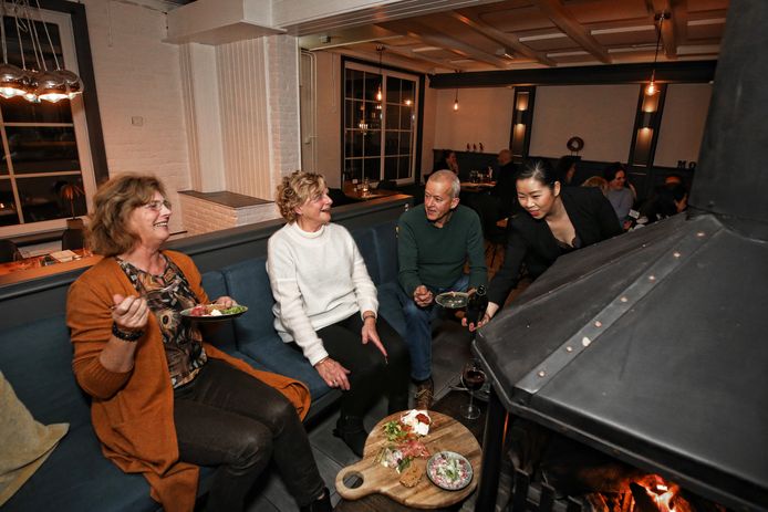 Bordje op schoot rond de open haard in restaurant Moment.