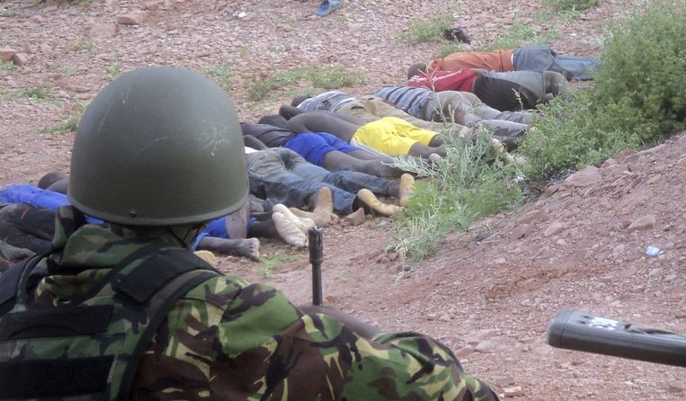 Een Keniaanse soldaat kijkt naar slachtoffers van de al-Shabaab-aanval bij de steengroeve. Beeld reuters