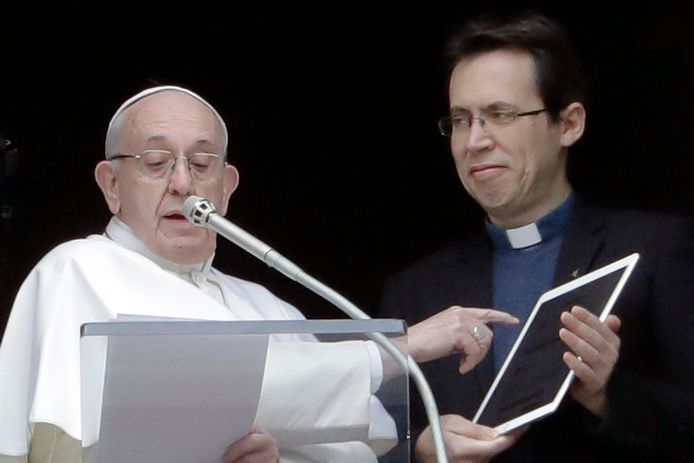 Paus Franciscus wijst zondag naar zijn tablet waarop de app Click To Pray is geïnstalleerd.