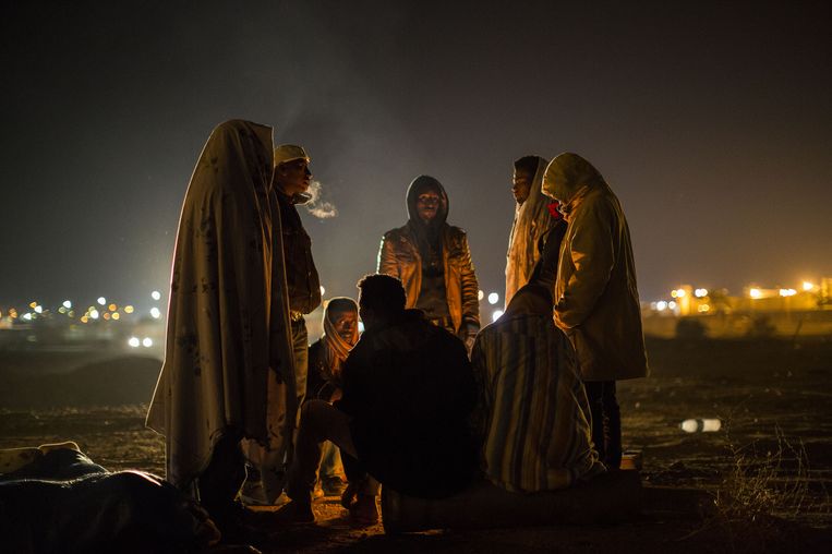 Afrikaanse asielzoekers verzamelen zich rond een vuur voor het Holot detentiecentrum. Beeld getty