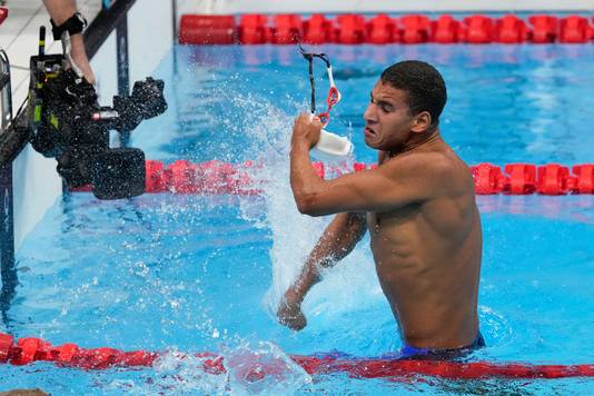 Ahmed Hafnaoui slaat op het water na zijn gouden race.