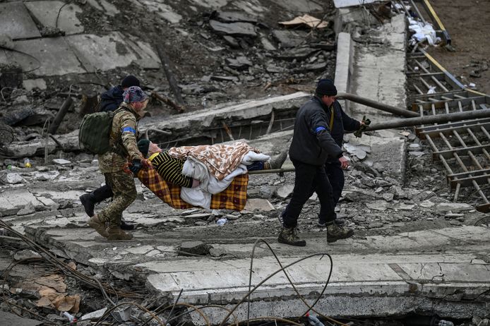 Oekraïense soldaten evacueren een bejaarde vrouw uit de stad Irpin.