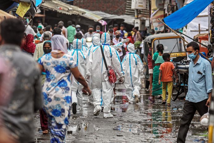 Hulpverleners dragen beschermende pakken in Mumbai, India.