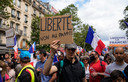 A protestor holds a sign which reads 'freedom, no to the pass' during a demonstration in Paris, France, Saturday, July 31, 2021. Demonstrators gathered in several cities in France on Saturday to protest against the COVID-19 pass, which grants vaccinated individuals greater ease of access to venues. (AP Photo/Michel Euler)