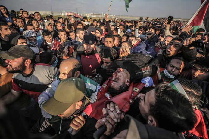 Betogers dragen het lichaam van een doodgeschoten man tijdens de protesten in Gaza.
