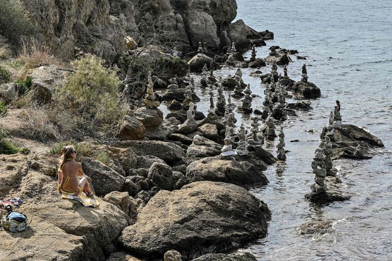 Een zonnende vrouw in Griekenland, waar nieuwe maatregelen zijn aangekondigd.  Beeld AFP