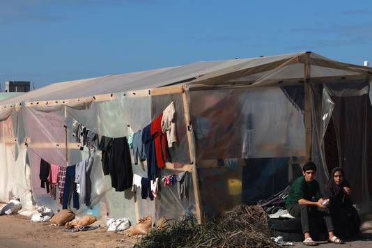 Rifugiati a Rafah vicino ad una tenda improvvisata e ad uno stendibiancheria.