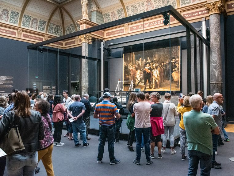 Bezoekers van het Rijksmuseum aanschouwen het beroemde schilderij ‘de nachtwacht’ vanachter glas.  Beeld Simon Lenskens