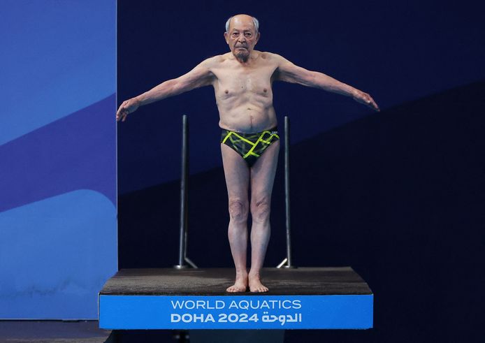 Oud-schoonspringer Taghi Askari bereidt zich voor op zijn demonstratiesprong tijdens het WK Zwemmen, vrijdag in Doha.