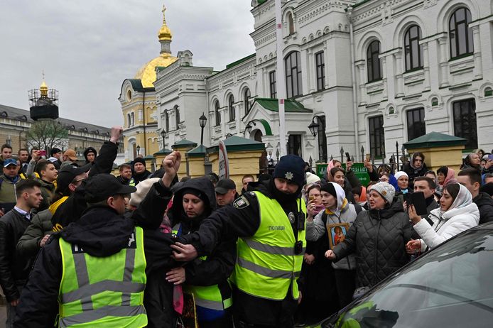Gelovigen van de Oekraïens-orthodoxe kerk, beschuldigd van het onderhouden van banden met Moskou clashen met pro-Oekraïense activisten buiten aan het historische klooster in Kiev. Beeld van gisteren.