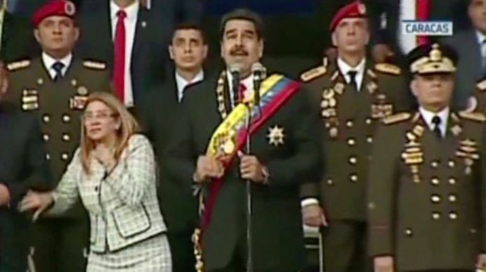 De president sprak in het centrum van de hoofdstad een militaire parade toe over de staat van de economie, toen vlakbij explosies klonken. Op televisiebeelden is te zien hoe mensen naast hem op het podium, onder wie Maduro's vrouw, schrikken en omhoog kijken.