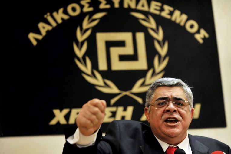De leider van de Gouden Dageraad, Nikos Michaloliakos, spreekt tijdens een persconferentie in Athene. Beeld AFP