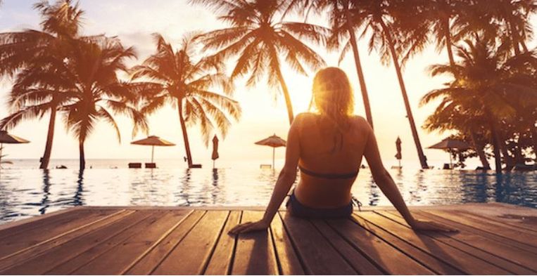 Vrouw bij palmbomen
 Beeld iStock