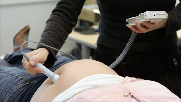 Een verloskundige controleert een zwangere vrouw. Beeld anp