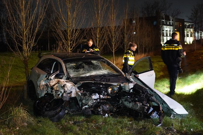 De politie doet onderzoek bij de auto die bij een ongeluk op de Industrieweg in Nijmegen het hele motorblok verloor.