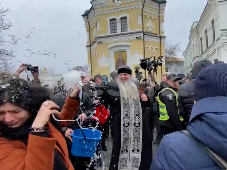 Oekraïense priester besprenkelt journalisten met water