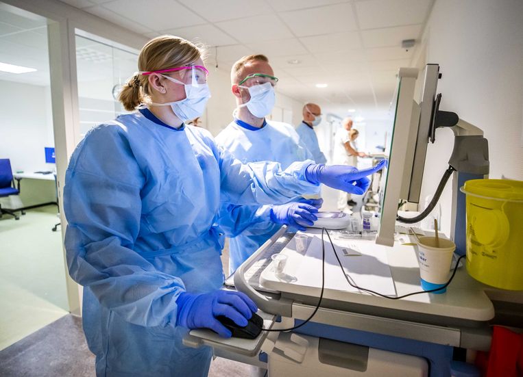 Verpleegkundigen maken medicijnen gereed voor een coronapatiënt  op de verpleegafdeling voor coronapatiënten van het HMC Westeinde ziekenhuis.  Beeld ANP