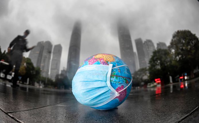 Een mini wereldbol met een mondmasker in Guangzhou, China.